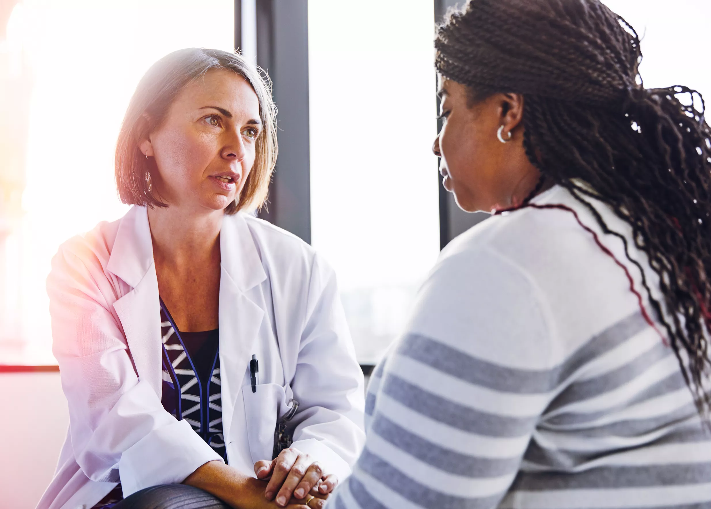 Primary Care; Doctor talking to woman patient in a health care setting